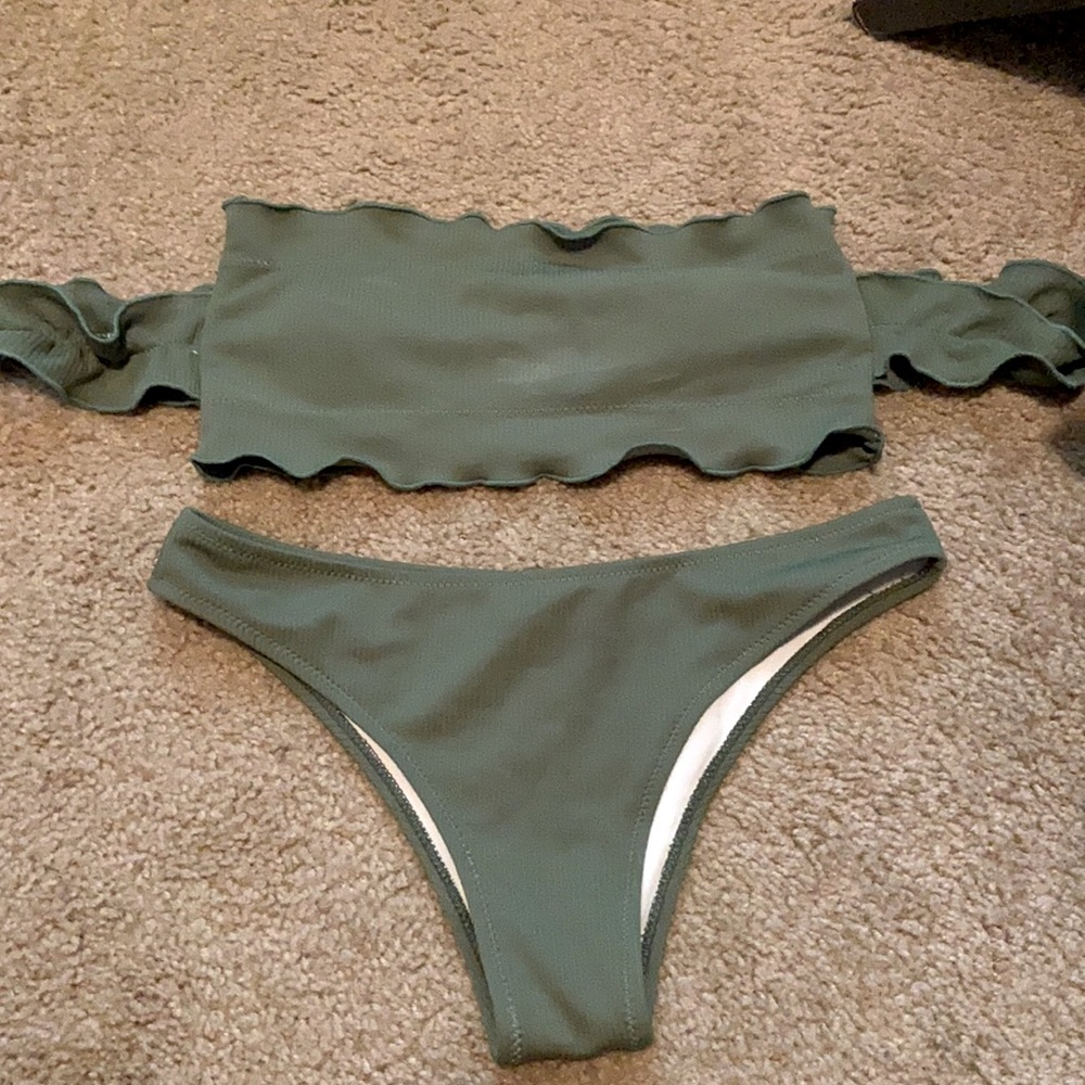 Green bathing suit with off the shoulder sleeves.